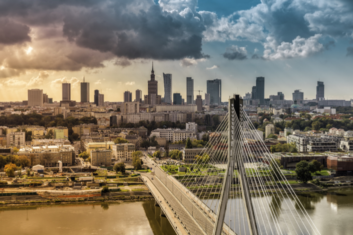 Warsaw skyline behind the bridge with light leak, Poland
